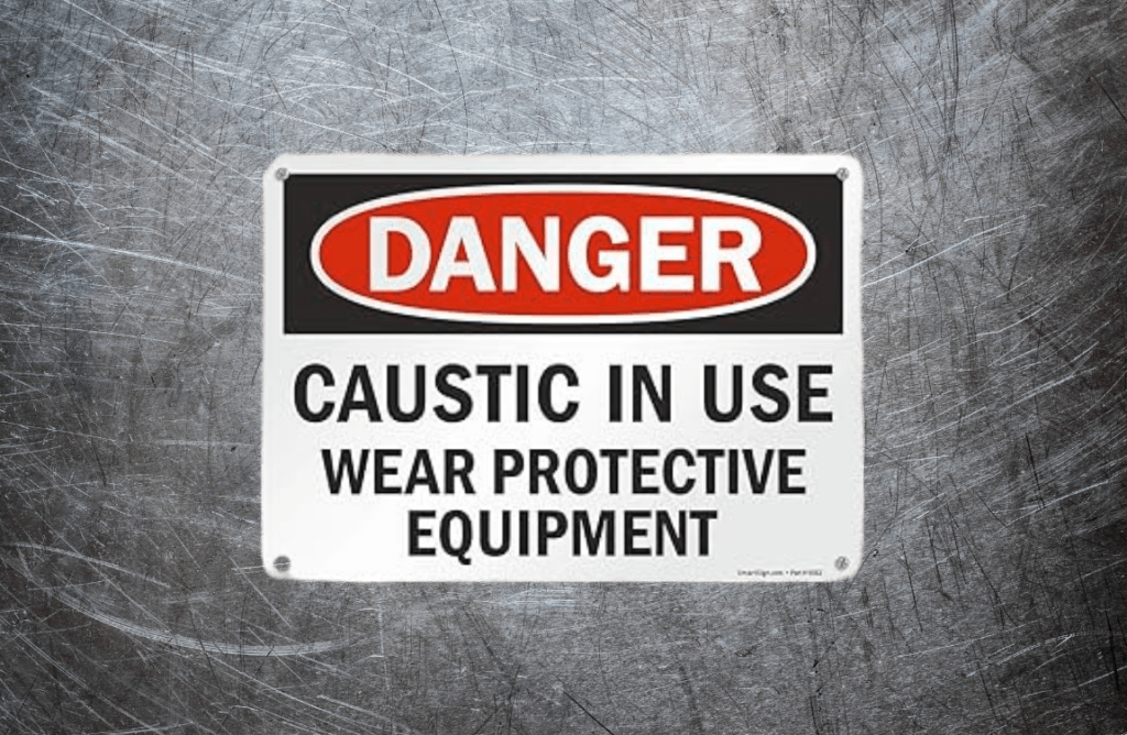 Warning sign: Danger, Caustic in use, Wear protective equipment